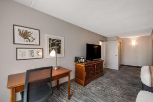 a hotel room with a desk and a television at Country Inn & Suites by Radisson, Fredericksburg South I-95 , VA in Fredericksburg