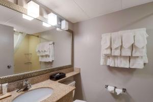 a bathroom with a sink and a mirror and towels at Country Inn & Suites by Radisson, Fredericksburg South I-95 , VA in Fredericksburg