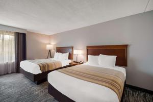 a hotel room with two beds and a window at Country Inn & Suites by Radisson, Fredericksburg South I-95 , VA in Fredericksburg