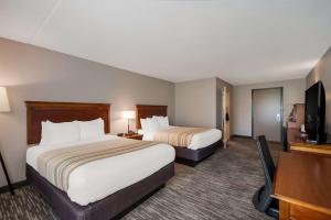 a hotel room with two beds and a flat screen tv at Country Inn & Suites by Radisson, Fredericksburg South I-95 , VA in Fredericksburg
