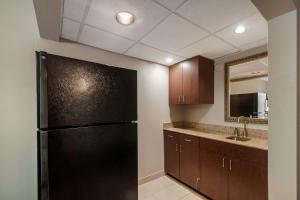 a kitchen with a black refrigerator and a sink at Country Inn & Suites by Radisson, Fredericksburg South I-95 , VA in Fredericksburg
