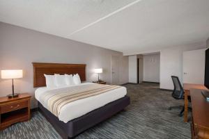 a hotel room with a large bed and a desk at Country Inn & Suites by Radisson, Fredericksburg South I-95 , VA in Fredericksburg