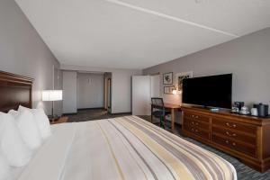 a hotel room with a bed and a flat screen tv at Country Inn & Suites by Radisson, Fredericksburg South I-95 , VA in Fredericksburg