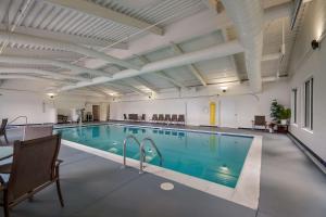 a large swimming pool with blue water in a building at Country Inn & Suites by Radisson, Fredericksburg South I-95 , VA in Fredericksburg