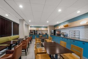 a dining room with wooden tables and chairs at Country Inn & Suites by Radisson, Fredericksburg South I-95 , VA in Fredericksburg