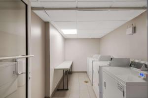 a hospital room with washing machines and a sink at Country Inn & Suites by Radisson, Fredericksburg South I-95 , VA in Fredericksburg
