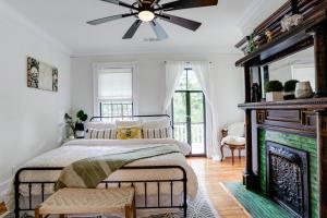 een slaapkamer met een open haard en een plafondventilator bij Oglethorpe Inn in Savannah