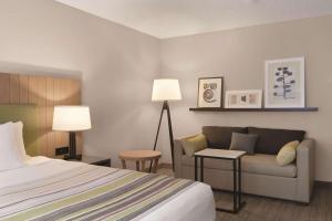 a hotel room with a bed and a couch at Country Inn & Suites by Radisson, Seattle-Bothell, WA in Bothell