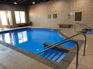 a large indoor swimming pool with blue water at Radisson Hotel River Falls in River Falls