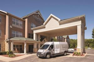 una furgoneta blanca estacionada frente a un edificio en Country Inn & Suites by Radisson, Madison Southwest, WI, en Fitchburg