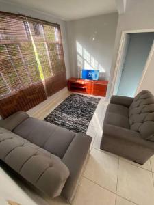 a living room with a couch and a large window at Casa em Praia do Flamengo - Salvador in Salvador