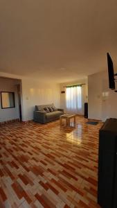 sala de estar con sofá y suelo de madera en Cabañas Millaray en 