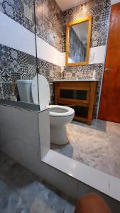 a bathroom with a toilet and a sink and a mirror at Cabañas Millaray in Huinganco