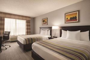 Habitación de hotel con 2 camas y ventana en Country Inn & Suites by Radisson, West Bend, WI, en West Bend