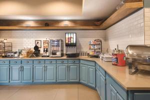 cocina con armarios azules y encimera en Country Inn & Suites by Radisson, West Bend, WI, en West Bend