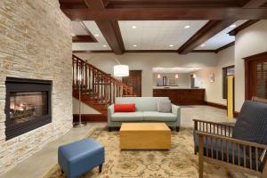 a living room with a couch and a fireplace at Country Inn & Suites by Radisson, Wausau, WI in Schofield