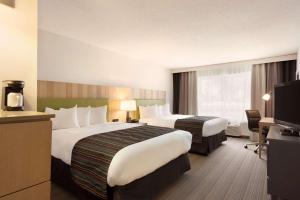 a hotel room with two beds and a television at Country Inn & Suites by Radisson, Chippewa Falls, WI in Chippewa Falls