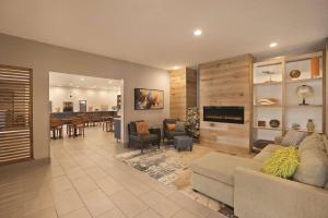 a living room with a couch and a dining room at Country Inn & Suites by Radisson, Green Bay North in Green Bay