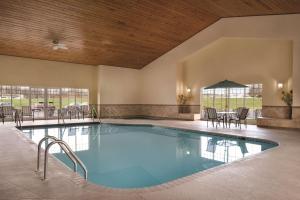 una grande piscina con sedie e tavolo di Country Inn & Suites by Radisson, Germantown, WI a Germantown