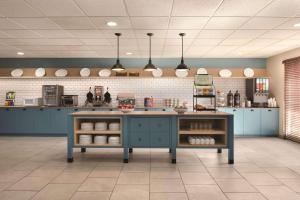 una cucina con armadi blu e bancone in una stanza di Country Inn & Suites by Radisson, Germantown, WI a Germantown