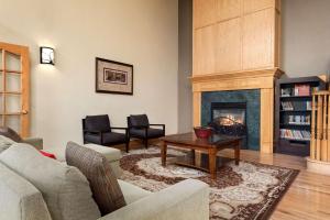 a living room with a couch and a fireplace at Country Inn & Suites by Radisson, Milwaukee Airport, WI in Milwaukee