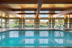 a swimming pool in a hotel lobby with windows at Country Inn & Suites by Radisson, Milwaukee Airport, WI in Milwaukee