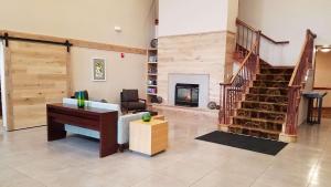 sala de estar con escalera y chimenea en Country Inn & Suites by Radisson, Milwaukee West Brookfield , WI en Brookfield