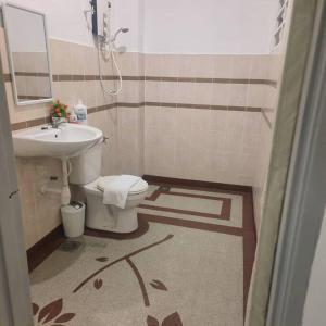 a bathroom with a toilet and a sink at Taiping Holiday Home in Taiping