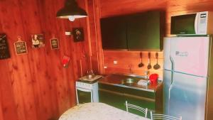 eine Küche mit einem weißen Kühlschrank und einer Spüle in der Unterkunft Cabanas dos Sonhos Barra de Ibiraquera in Imbituba