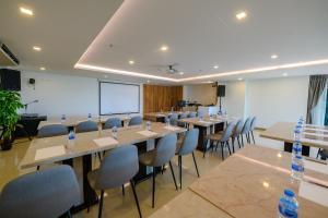 einen Konferenzraum mit Tischen, Stühlen und einem Bildschirm in der Unterkunft IRIS PALACE in Pattaya South