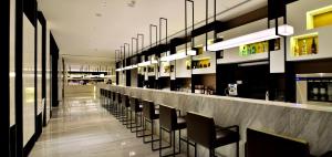 um restaurante com um bar com cadeiras e luzes em Wuhan Ziyuan Hotel em Wuhan