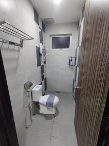 een kleine badkamer met een toilet en een raam bij 16 Paxs Bungalow Homestay Hutan Melintang by Aloha in Hutan Melintang