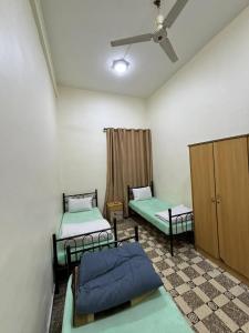 2 Einzelbetten in einem Zimmer mit einer Decke in der Unterkunft Roman Theater Hotel in Amman