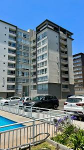 a parking lot with cars parked in front of a building at Departamento de dos dormitorios en La Serena in La Serena