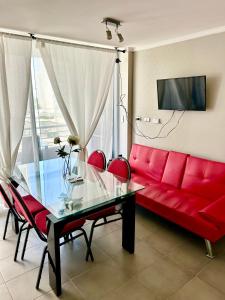 a living room with a red couch and a glass table at Departamento de dos dormitorios en La Serena in La Serena