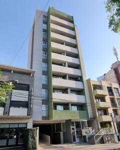 un edificio de apartamentos alto con un jardín en COSTANERA APART 2 en San Salvador de Jujuy