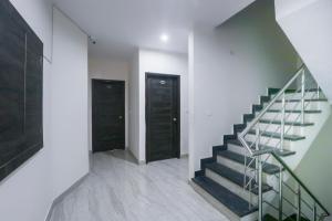 a hallway with two black doors and a staircase at OYO Kings Inn in Ludhiana