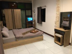 a bedroom with a bed and a television in it at แสนดีเพลส เกสเฮ้าท์ จอมทอง in Chom Thong