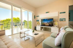 a living room with a couch and a tv at Elegancia y Relajación en Puntarena Beach Town, Buenaventura in Coclé