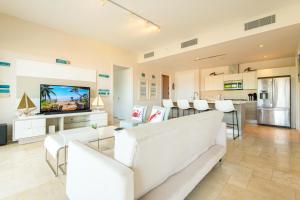 een woonkamer met witte meubels en een flatscreen-tv bij Elegancia y Relajación en Puntarena Beach Town, Buenaventura in Coclé