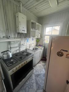 a kitchen with a stove and a sink and a refrigerator at Cabañas 644 in Porvenir