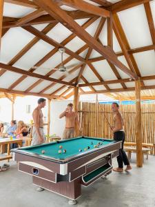 Un groupe d'hommes autour d'un billard dans l'établissement Seaesta Komodo Hostel & Hotel, à Labuan Bajo