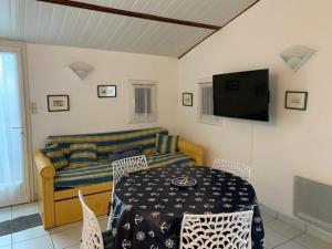 ein Wohnzimmer mit einem Tisch und einem Sofa in der Unterkunft Maison Bretignolles-sur-Mer, 3 pièces, 4 personnes - FR-1-231-300 in Brétignolles-sur-Mer
