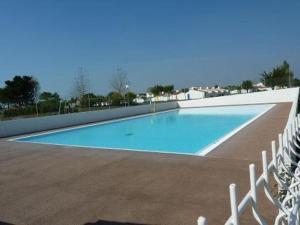 ein großer blauer Pool mit einem Zaun um ihn herum in der Unterkunft Maison Bretignolles-sur-Mer, 3 pièces, 4 personnes - FR-1-231-300 in Brétignolles-sur-Mer