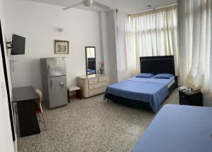 - une chambre avec un lit, une commode et un miroir dans l'établissement Hotel Sandiego, à Puerto Berrío