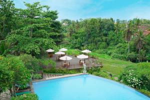 an overhead view of a swimming pool with umbrellas at Royal Casa Ganesha in Ubud