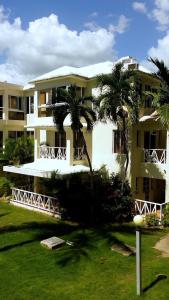 a large building with palm trees in front of it at EL Bonito II Juan Dolio DR 2 room sleeps6 1queen bed 2twin bed 1sofa bed in Juan Dolio