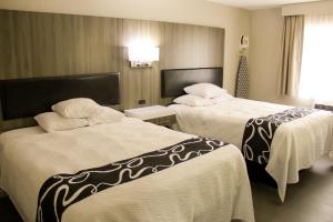 a hotel room with two beds and a window at Super 8 by Wyndham Oskaloosa IA in Oskaloosa