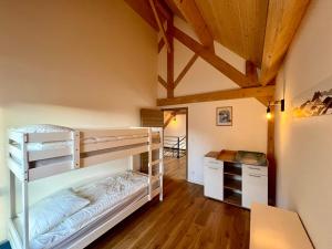 a bedroom with bunk beds in a room with wooden floors at Chalet 5 pièces, garage, terrasse, 8 pers - FR-1-608-263 in Le Mont-Dore +9 photos