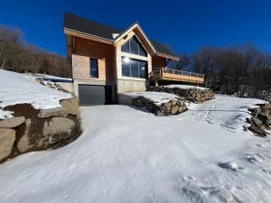 a house with a driveway in the snow at Chalet 5 pièces, garage, terrasse, 8 pers - FR-1-608-263 in Le Mont-Dore